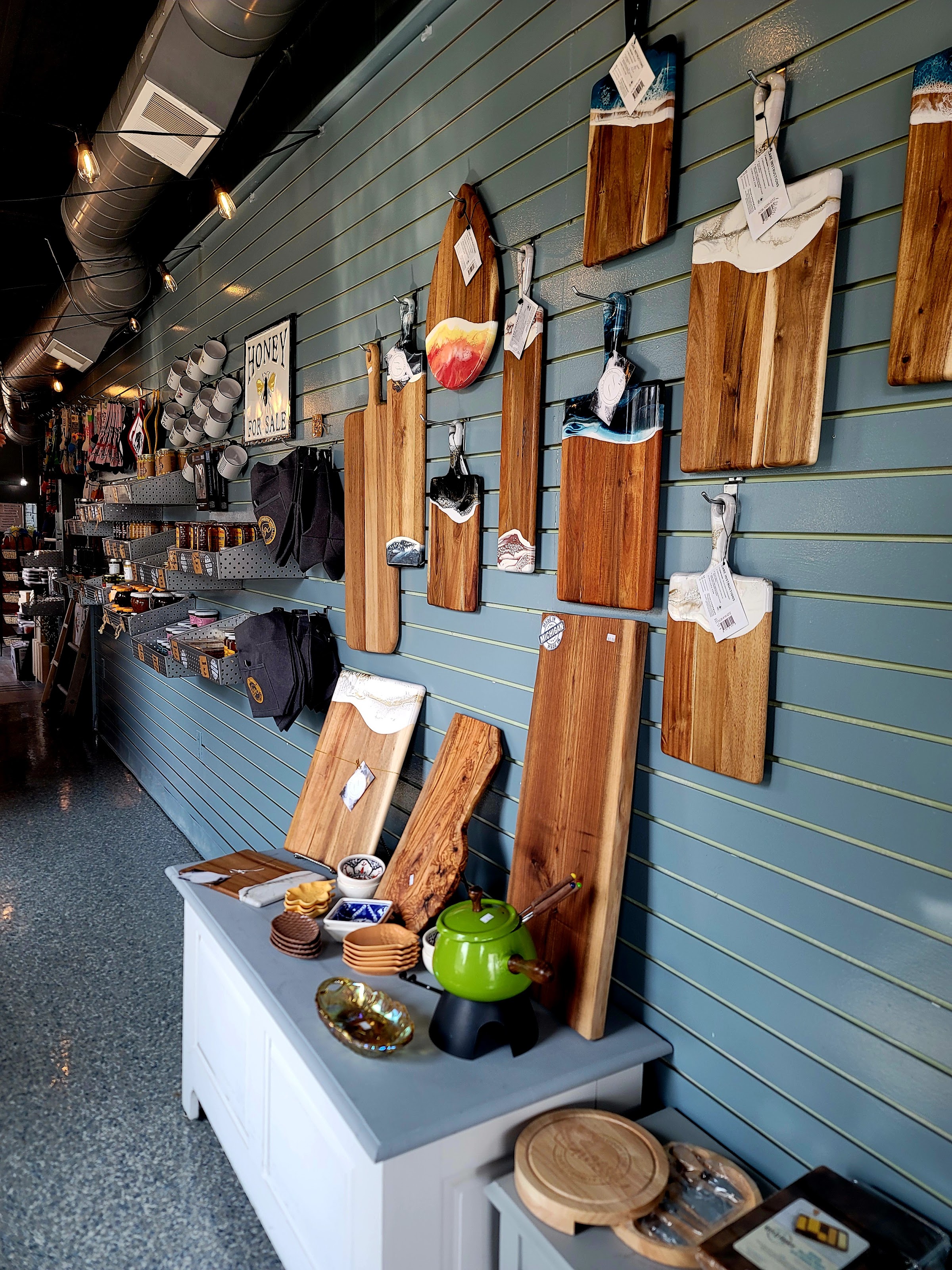 A wall of wooden serving boards and shelves of accompaniments inside the shop.
